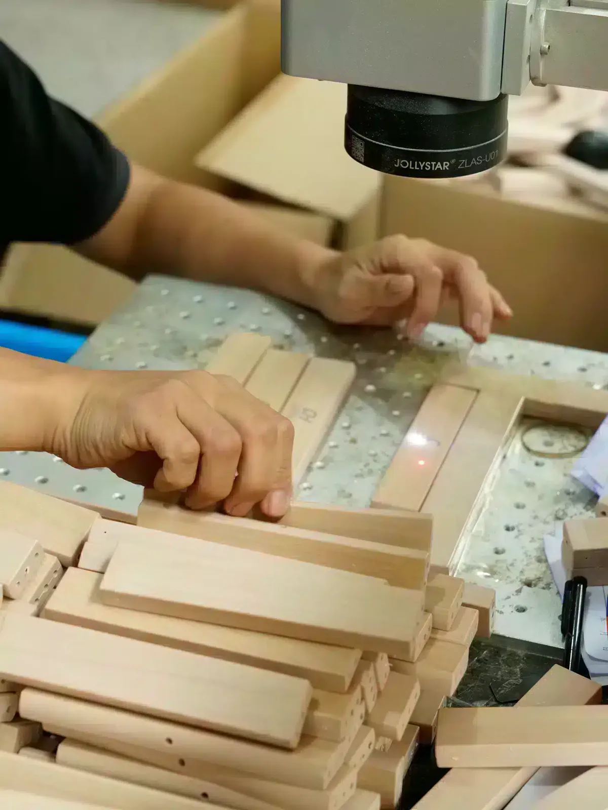 Laser engraving a logo onto a hanger at the Fanan Display factory